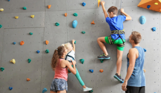 climbing coaches helping two children
